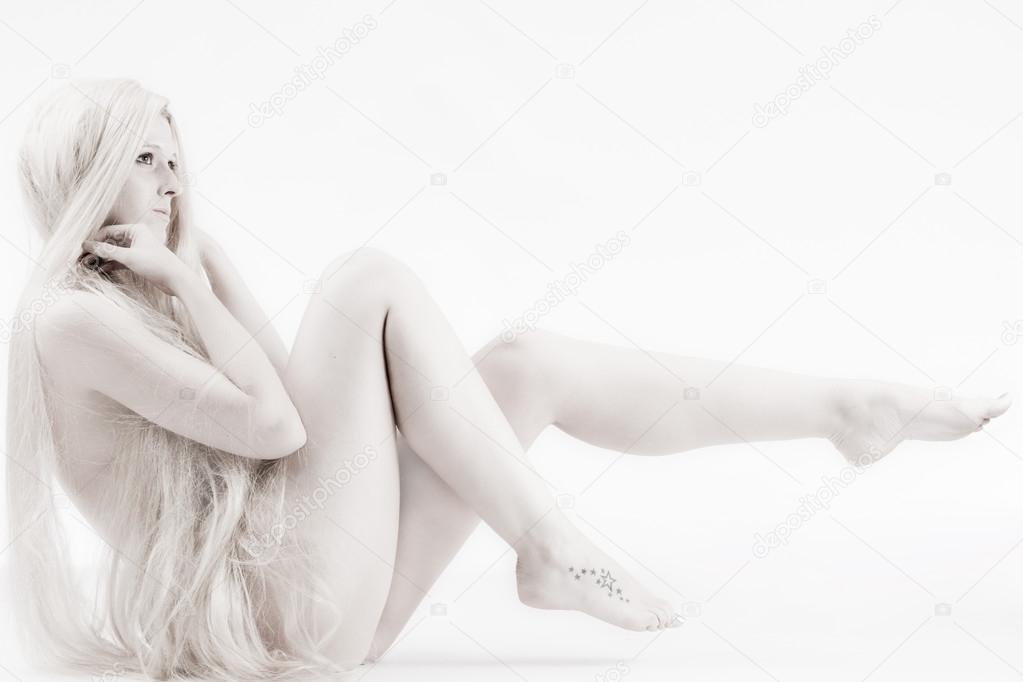 Long blond haired artistic beauty pulling up her legs