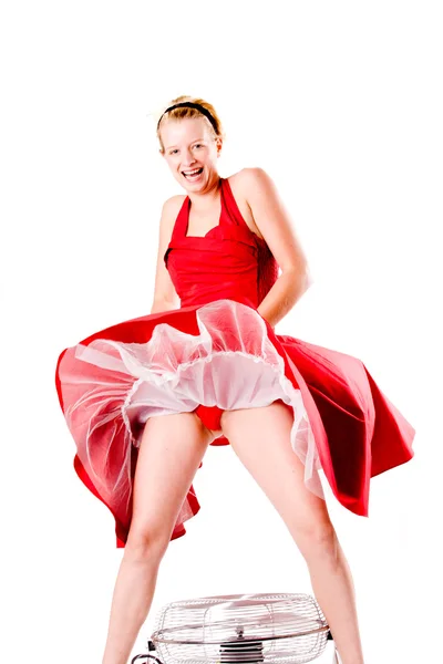 Chica divertida en vestido de gala rojo jugando con un ventilador riendo — Foto de Stock