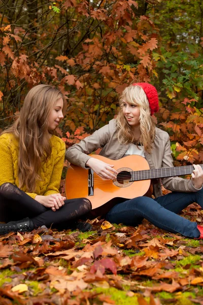 Freundinnen, die eine schöne Zeit mit einer Gitarre haben — Stockfoto