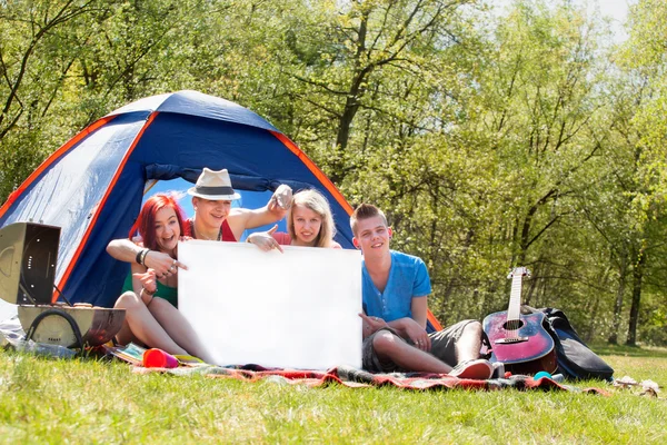 Jugendliche auf einem Zeltplatz mit leerem Schild — Stockfoto