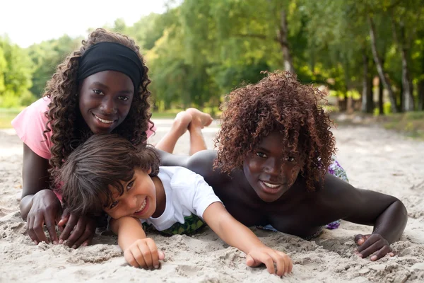 Bambini etnici sorridenti sulla spiaggia — Foto Stock