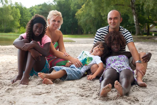 Multikulturális család a strandon — Stock Fotó