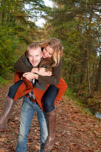 Junges paar reitet huckepack — Stockfoto