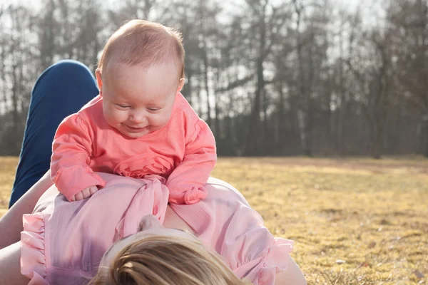 Ребенок веселится на животе мамочки — стоковое фото