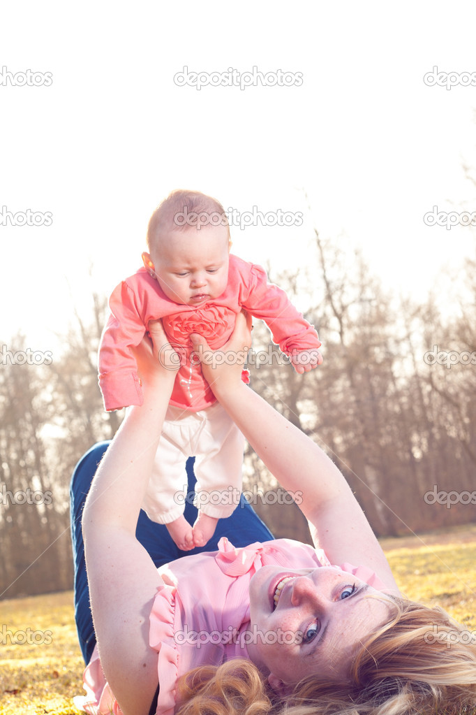 Mother is smiling when holding up her baby