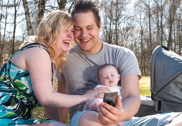 Família jovem está sorrindo enquanto toma uma selfie — Fotografia de Stock