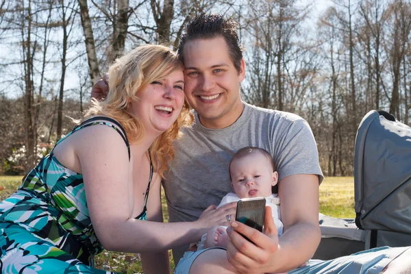 Família jovem está tirando uma foto com o smartphone — Fotografia de Stock