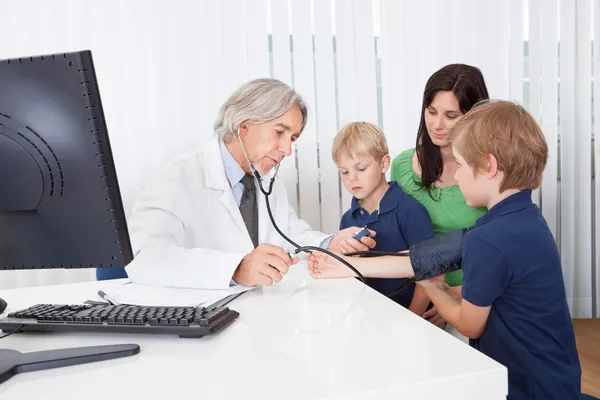 Madre con hijos en el consultorio médico — Foto de Stock