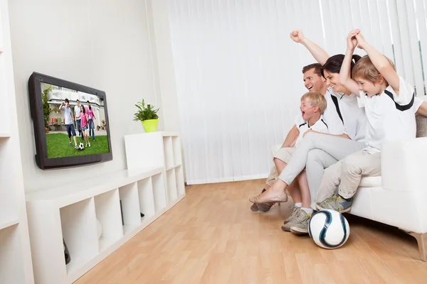 Молодая семья смотрит футбол — стоковое фото