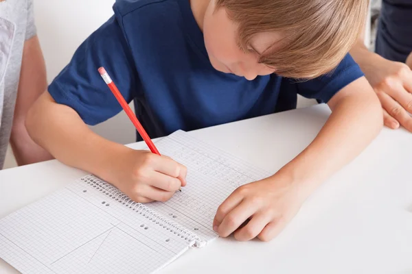 Jeune garçon faisant ses devoirs — Photo