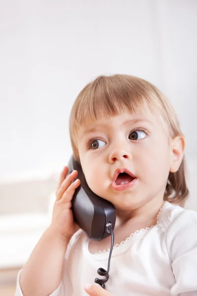 Niña escuchando un teléfono — Foto de Stock