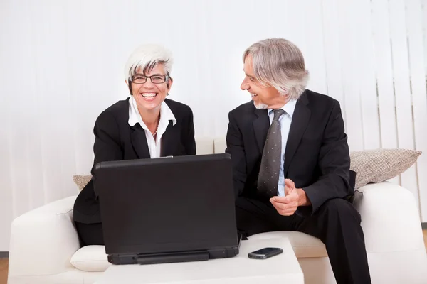 Partner commerciali che lavorano su un laptop — Foto Stock