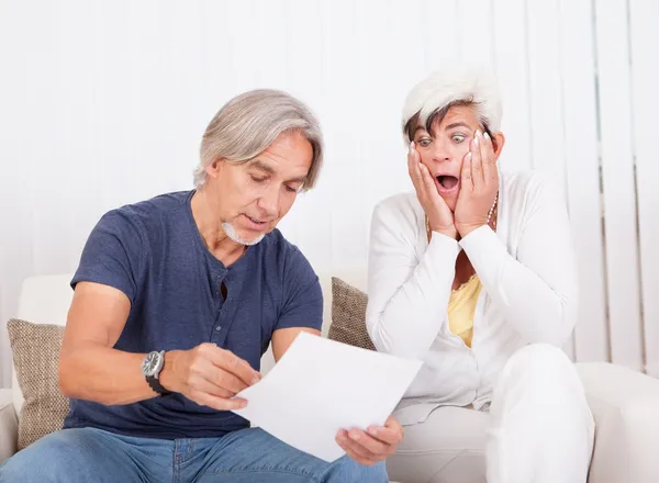 Senior couple discussing a document — Stock Photo, Image