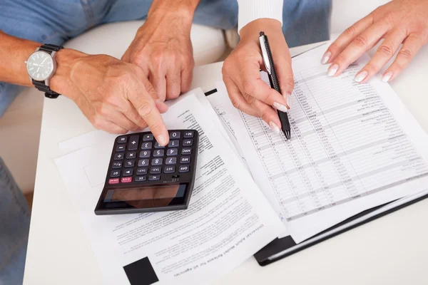 Emocionada pareja de mediana edad haciendo finanzas en casa —  Fotos de Stock