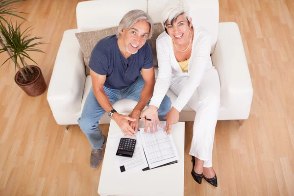 Entusiasmado casal de meia-idade fazendo finanças em casa — Fotografia de Stock
