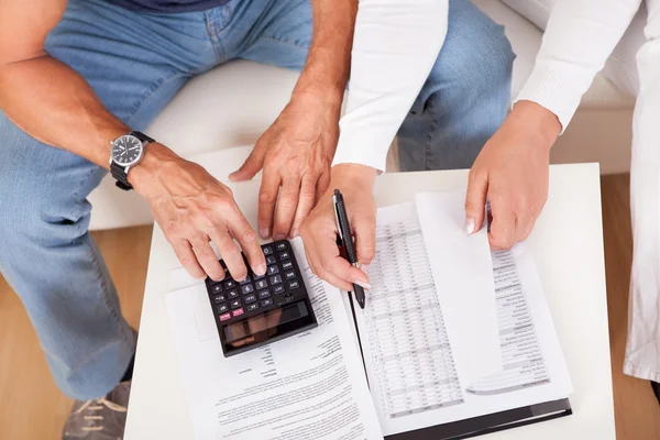 Emocionada pareja de mediana edad haciendo finanzas en casa — Foto de Stock