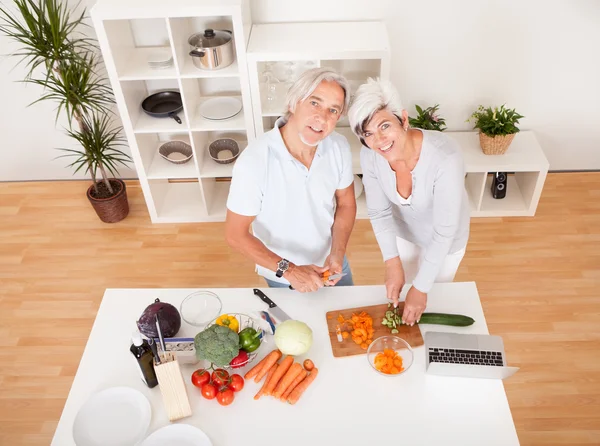 Paar mittleren Alters bereitet eine Mahlzeit zu — Stockfoto