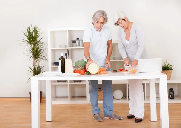 Middle-aged couple preparing a meal — Stock Photo, Image