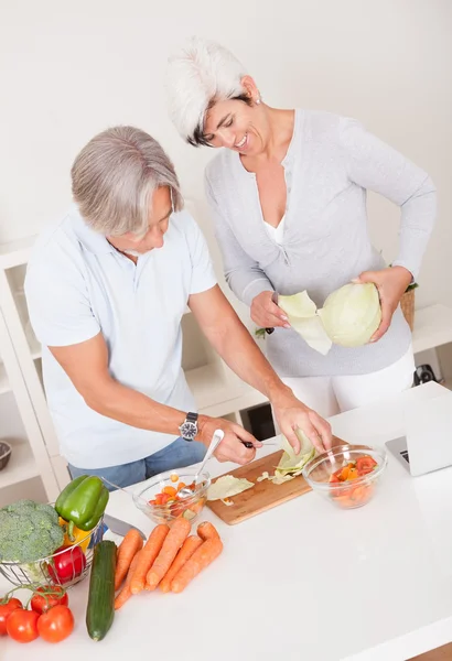 Casal de meia-idade preparando uma refeição — Fotografia de Stock