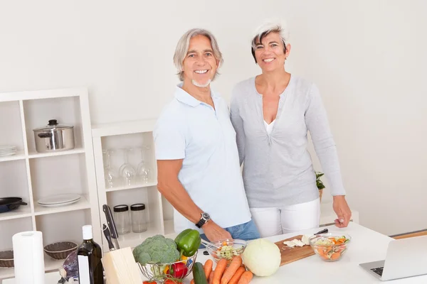 Middle-aged couple preparing a meal — Stock Photo, Image