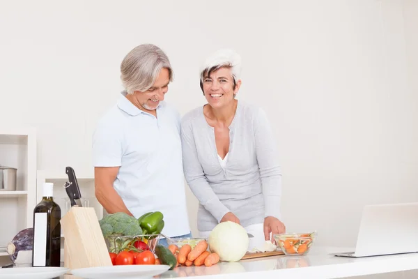 Middle-aged couple preparing a meal — Stock Photo, Image