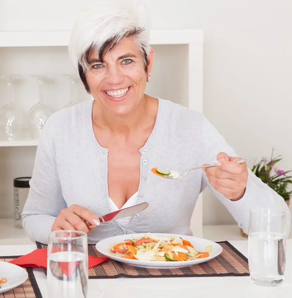 Senior woman eating a meal — Stock Photo, Image