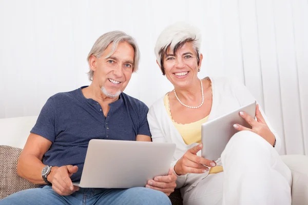 Happy couple at home using laptop — Stock Photo, Image