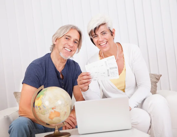 Ecstatic couple displaying holiday tickets — Stock Photo, Image