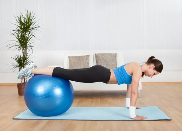 Mujer haciendo ejercicio con pelota de ejercicio — Foto de Stock