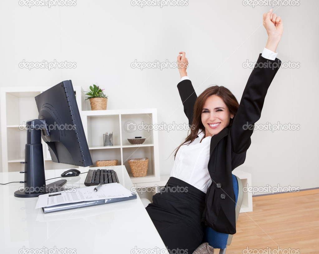 Businesswoman Cheering At Desk