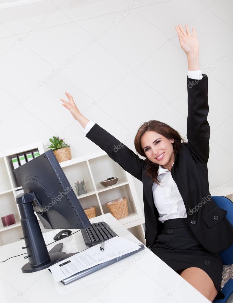 Businesswoman Cheering At Desk