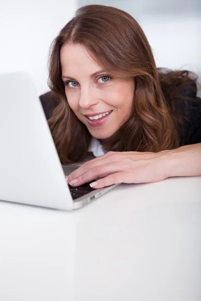 Mujer sonriente con un portátil — Foto de Stock