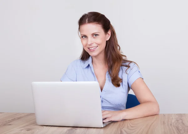 Freundliche Frau, die am Laptop arbeitet — Stockfoto