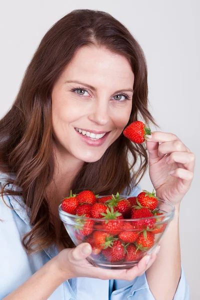 Vrouw genieten van een kom van aardbeien — Stockfoto