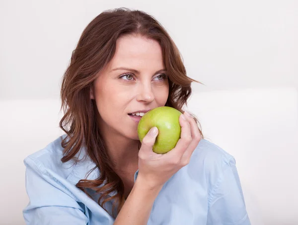 Femme mangeant une pomme verte saine — Photo