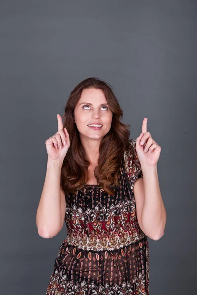 Woman wijzend boven haar hoofd — Stockfoto