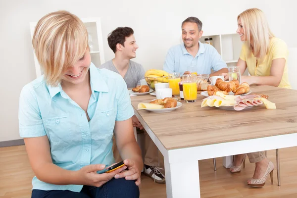 Tiener texting in keuken — Stockfoto