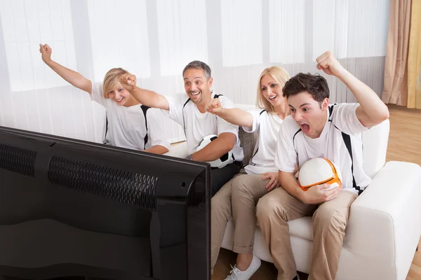 Famiglia giubilante guardare la televisione — Foto Stock