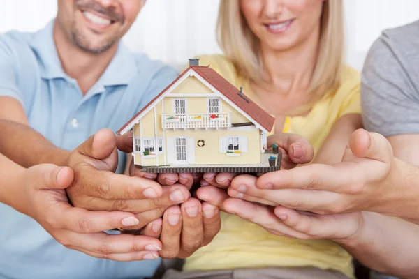 Lycklig familj håller en modell hus — Stockfoto