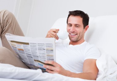 genç adam elinde gazete okuyan Kupası holding