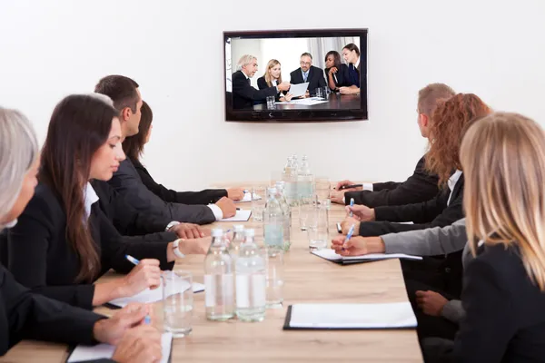 Uomini d'affari seduti al tavolo delle conferenze — Foto Stock