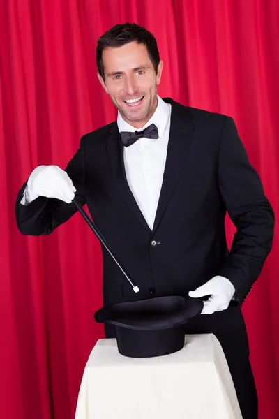 Een goochelaar in een zwart pak — Stockfoto