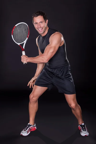 Молодий чоловік тримає тенісну ракетку — стокове фото