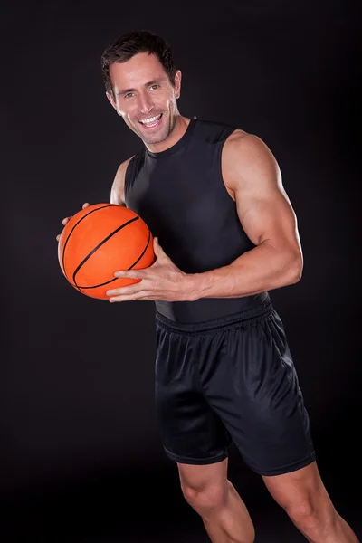 Joven sosteniendo baloncesto — Foto de Stock