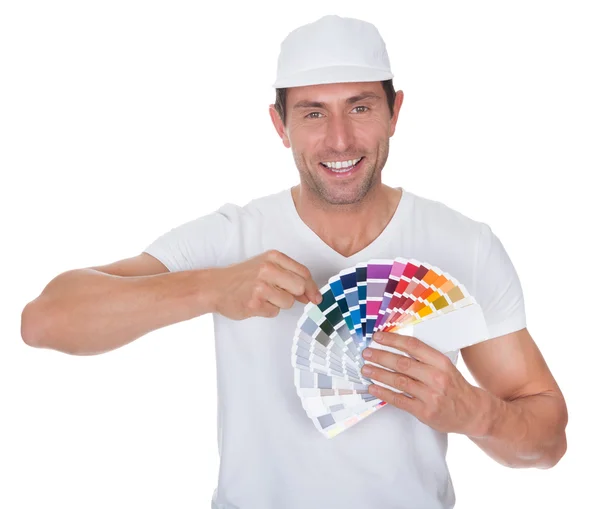 Pintor sosteniendo un rodillo de pintura y espectro — Foto de Stock