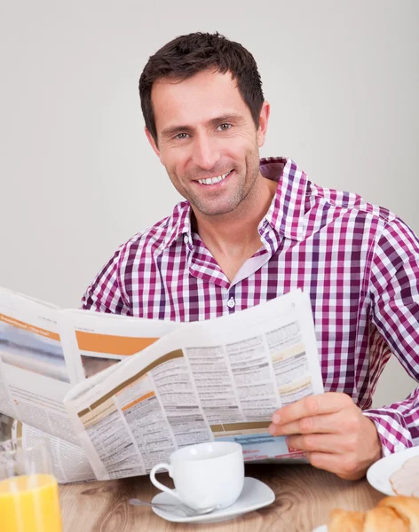 Νεαρός άνδρας διαβάζοντας εφημερίδα στο πρωινό — Φωτογραφία Αρχείου