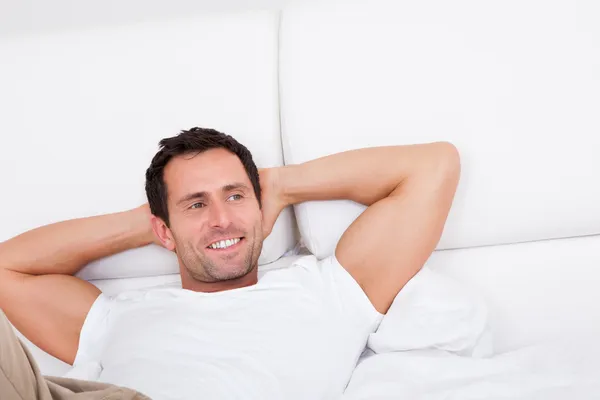 Porträt eines jungen Mannes, der es sich im Bett bequem macht — Stockfoto