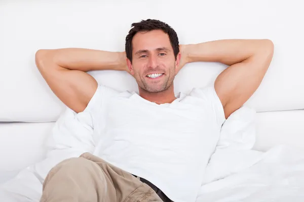 Retrato do jovem relaxante na cama — Fotografia de Stock