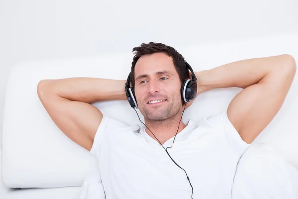 Joven escuchando música en los auriculares — Foto de Stock