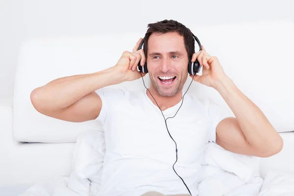 Genç bir adam üzerinde kulaklık müzik dinleme — Stok fotoğraf